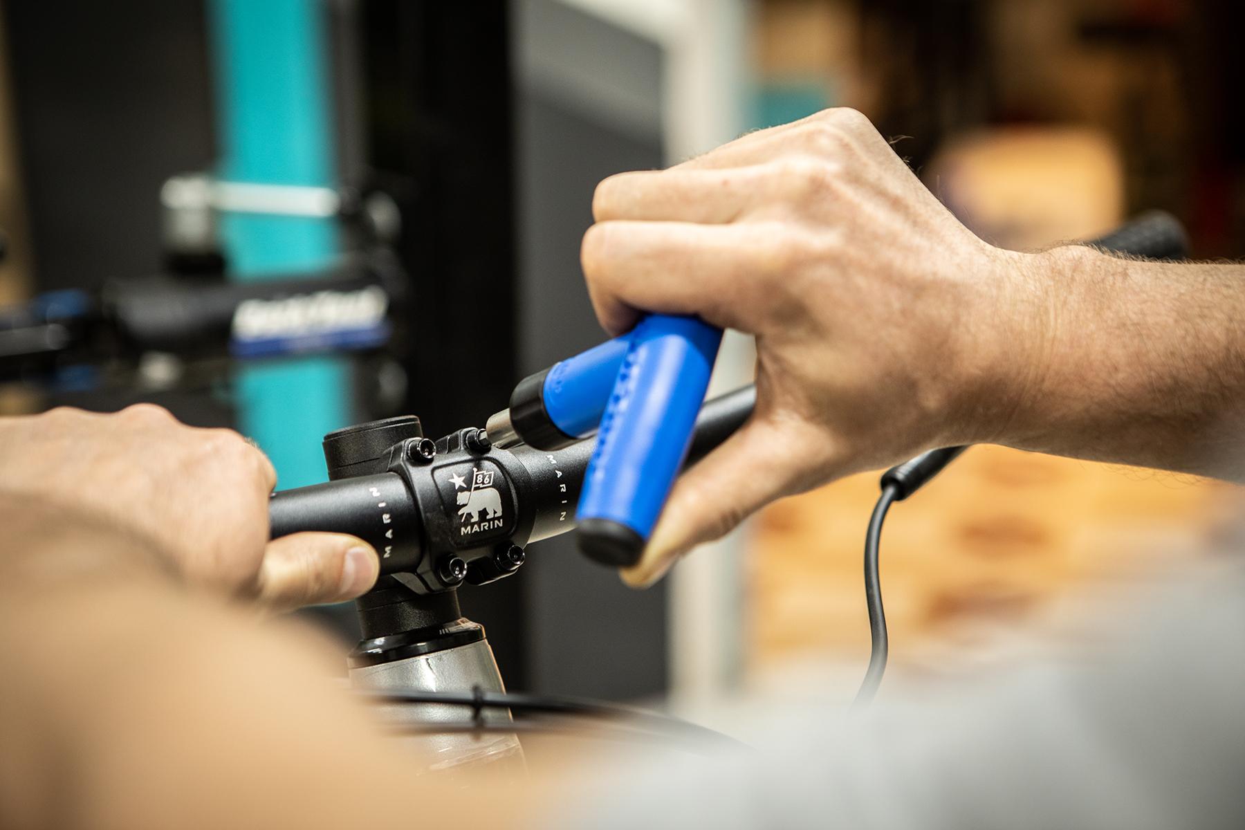 A professional bike mechanic assembles a new Marin bike in El Bike Project's Sacred Valley bike shop. The mechanic works with quality Park Tool tools
