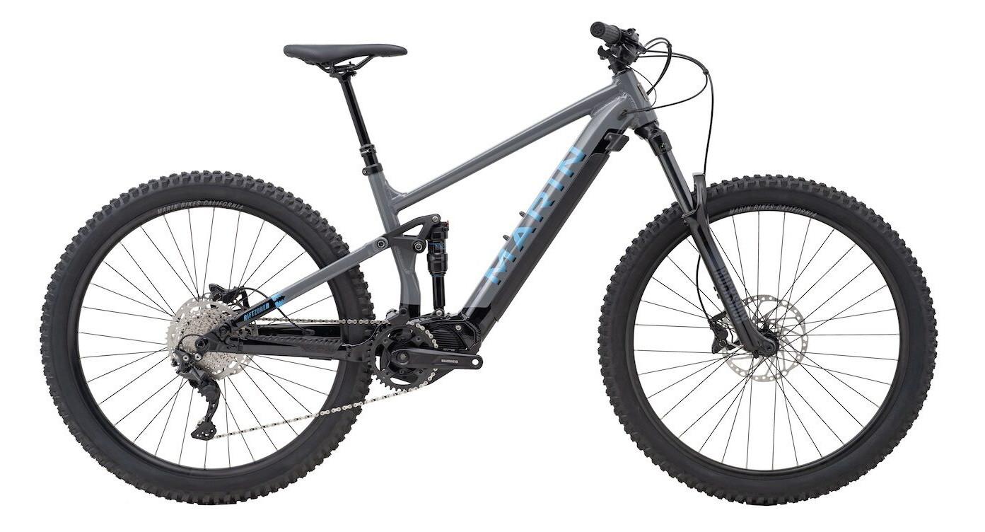 A black and gray mountain bike with thick tires and disc brakes, featuring a full suspension frame.